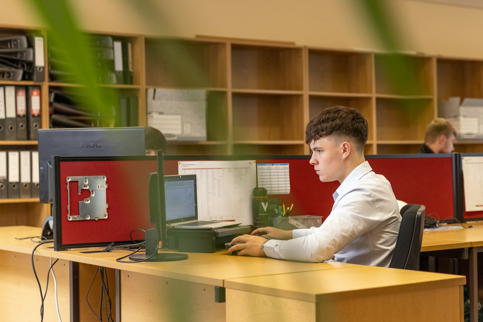 Werknemer controleert werk op een computerscherm op kantoor